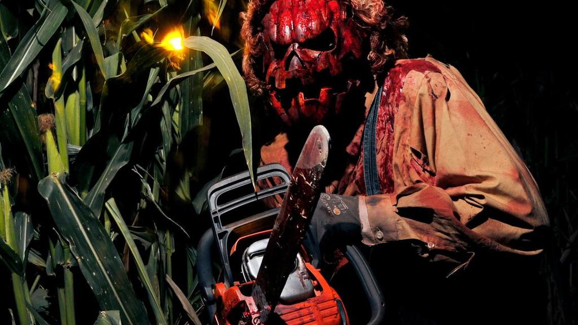 A chainsaw-wielding actor awaits guests at last year’s Raisin Hell Ranch in Madera.