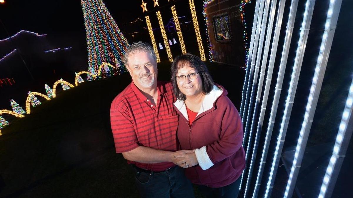 Terry Toews, left, and his wife Deb stand in front of their home on Santa Claus Lane in Clovis. The couple run the non-profit Clovis Festival of Lights, which has 16 houses of synchronized lights on their block featuring more than 100,000 LED lights.