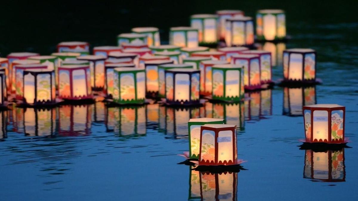 Floating lanterns glow on the calm water as families and friends gather for Toro Nagashi, the Floating Lantern Ceremony, to mark the end of Obon celebrations.