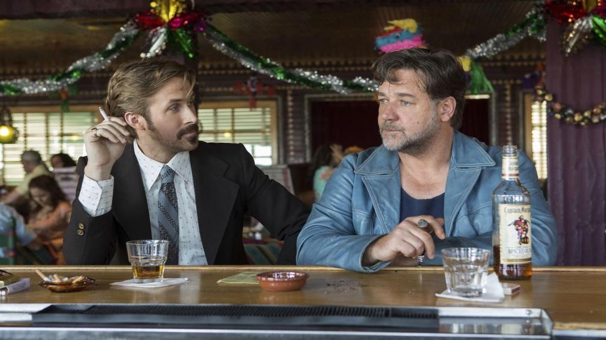 Characters played by Ryan Gosling and Russell Crowe in “The Nice Guys” smoke.