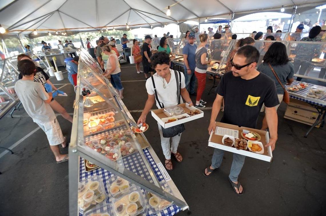 Luis Leyva, left, and Adrian Rivera, both of Fresno, select dishes in the Outdoor Mega Booth Grill at the 2016 Greek Fest. This year’s festival runs Friday, Aug. 23, through Sunday, Aug. 25, at St. George Greek Orthodox Church.