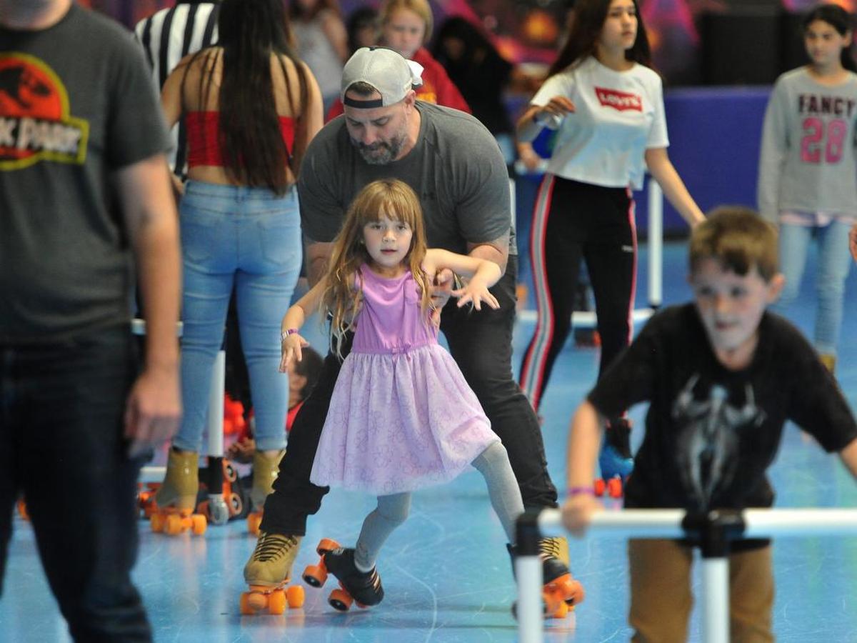 James Piazza steadies his 5-year-old daughter, Ella, from a near-fall as they roll along at the new United Skates of America in Clovis on Saturday, April 6, 2019.