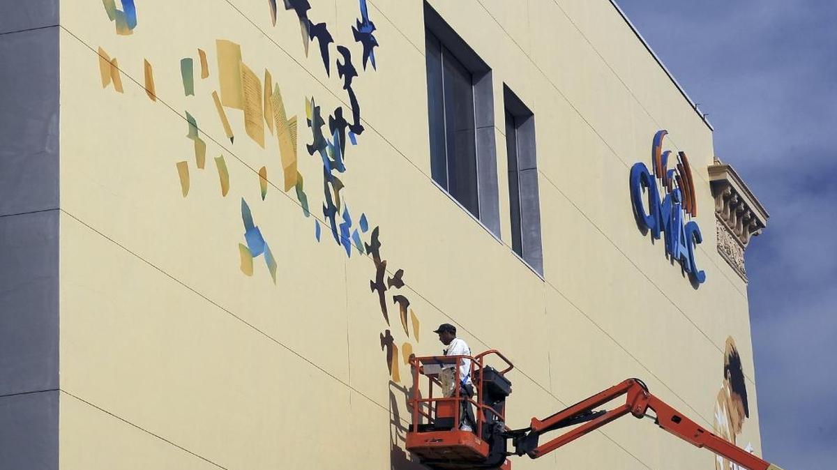 The mural on the south face of the former Fresno Bee building in progress in February. Artists Mauro Carrera, pictured, and Francisco Letelier will dedicate and name their five-story work at an event Thursday morning, May 11.