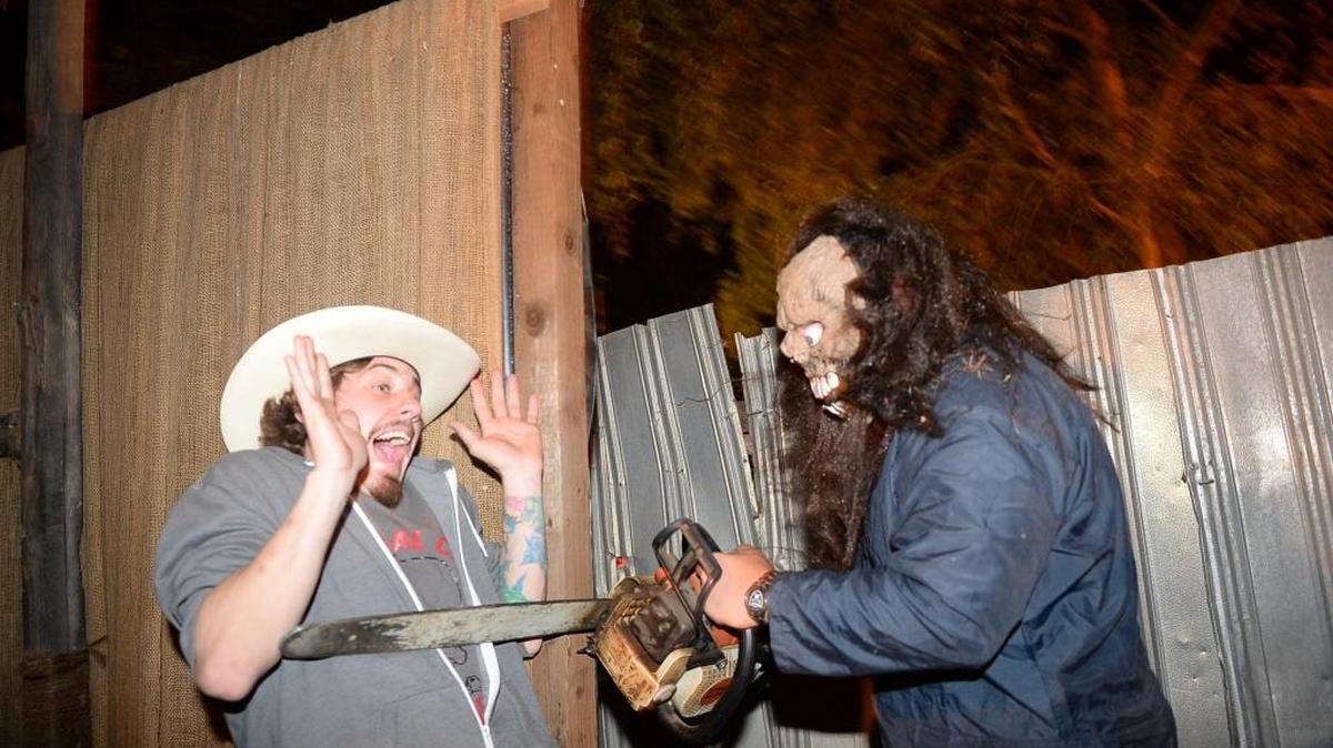 Devin Carter feigns fear as Tyler Benard scares him with a chainsaw at Hobb’s Grove.
