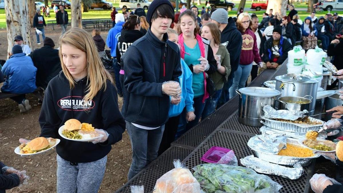 Marissa Sipe, left, 14, a member of the Rebellion Youth Group from Yosemite Lakes Park Community Church, helps to take plates of hot food to the homeless and needy in 2016 during the traditional day-before-Thanksgiving event at the eucalyptus grove at Roeding Park. The event, hosted by Bread of Life Ministries, has provided food and clothing for the needy for 30 years. The group feeds the homeless every Wednesday.
