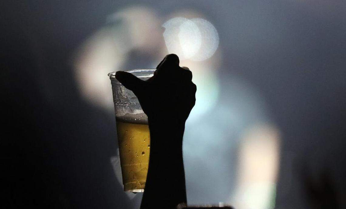 A fan of Fuerza Regida toasts with a beer as the “Otra Peda” tour stop at the Save Mart Center in Fresno drew a sellout crowd on Aug. 5, 2023.