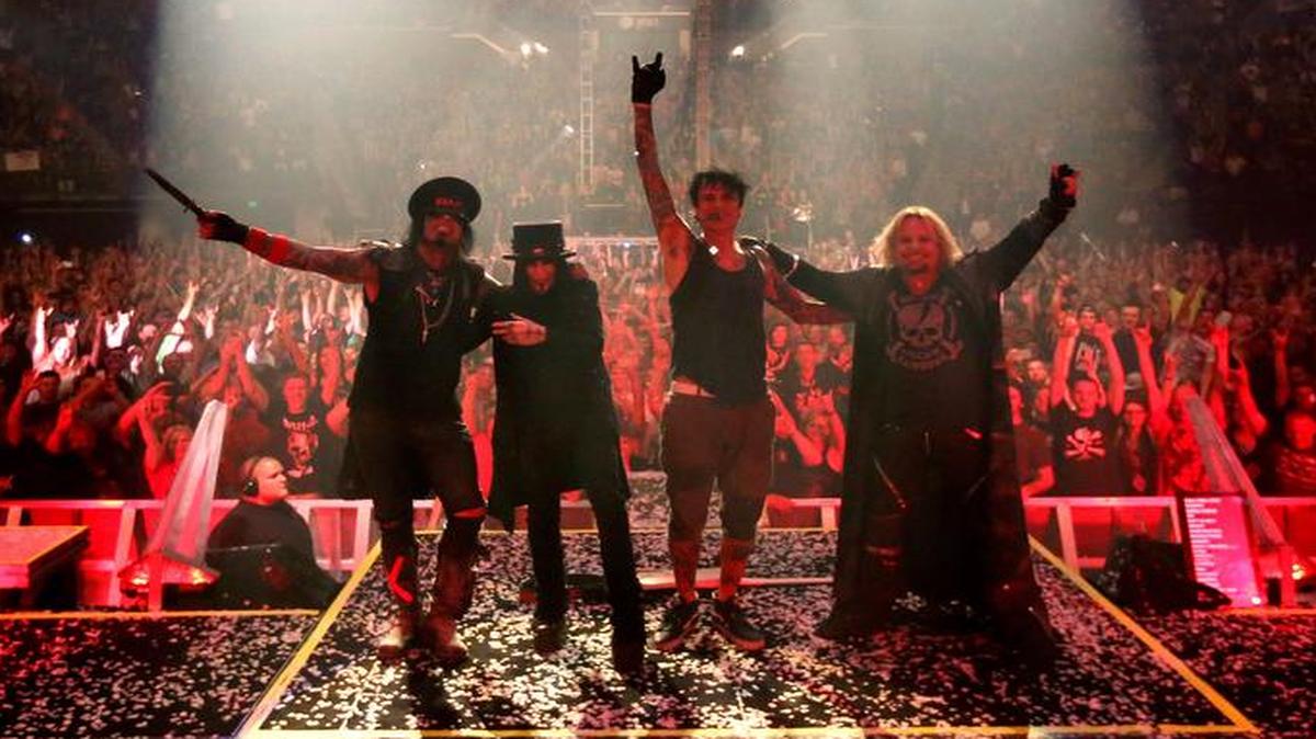 From left, Mötley Crüe’s Nikki Sixx, Mick Mars, Tommy Lee and Vince Neil celebrate the end of another concert as the audience cheers at the Matthew Knight Arena in Eugene, Ore., on July 22, 2015.