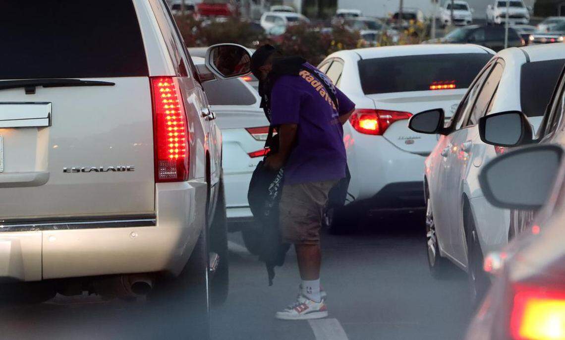 Street vendors hawking Fuerza Regida merchandize take advantage of clogged offramp off Highway 168 and Shaw Avenue on Aug. 5, 2023.
