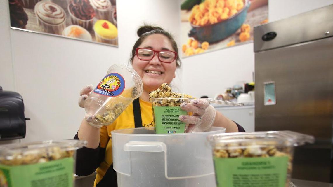 If you're looking for a sweet place to shop for fresh baked goodies, Grandpa's Popcorn should do the trick. Here, Yvonne Shipley fills containers full of popcorn.