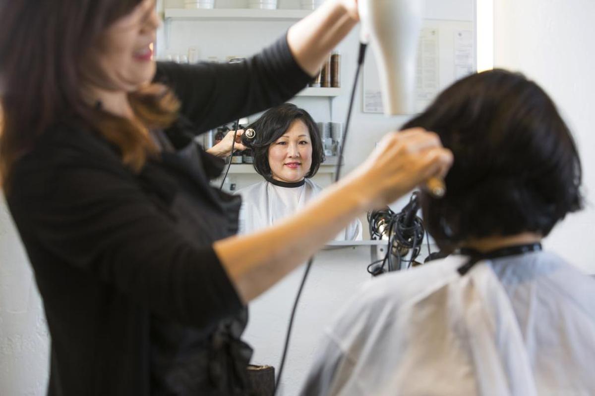 HAIR SALON: Uni Kim styles the hair of Laura Davis at La Vogue Beauty Shoppe, which was established in 1924.