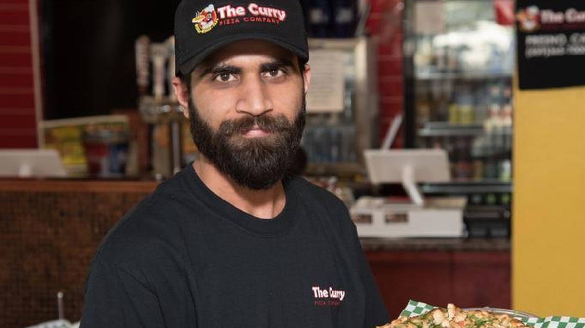 Jag Singh with a Butter Chicken pizza from The Curry Pizza Company.