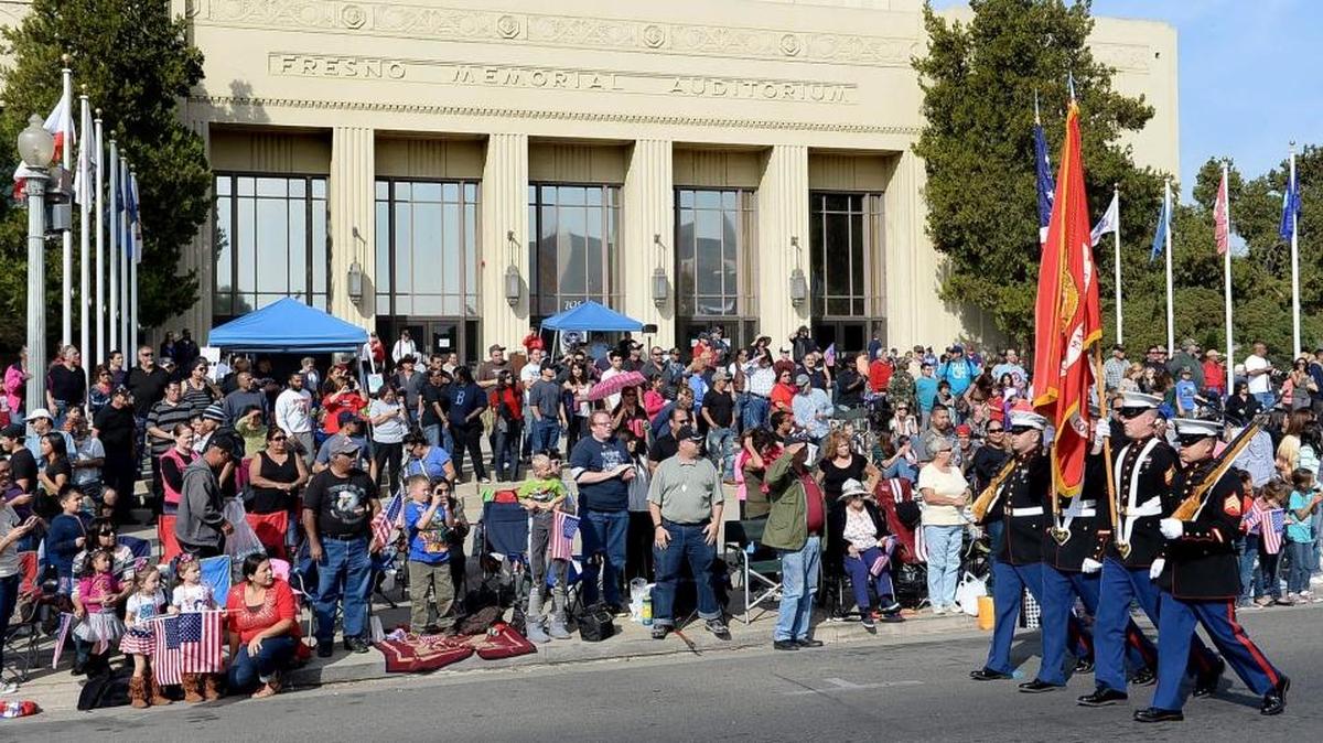 A Marine Corps color guard march down Fresno Street in front of the Fresno Memorial Auditorium during the Fresno Veterans Day Parade in 2013.