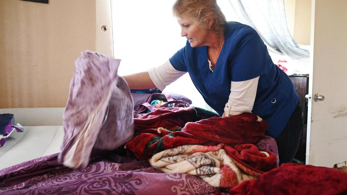 La trabajadora del programa de Servicios de Ayuda a Domicilio (IHSS) Wendy Davenport hace la cama para su clienta Jovonna "JoJo" Martínez, el miércoles 15 de marzo de 2023, en Fresno. Davenport y otros trabajadores de SEIU buscan un aumento salarial de $16.10 por hora a $20 por hora por el trabajo que realizan.