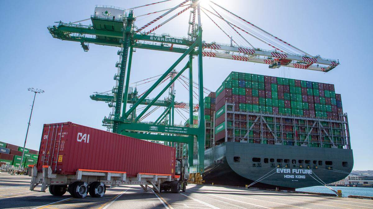 Workers load and unload containers Wednesday, Oct. 13, 2021, at the Evergreen terminal in the Port of Los Angeles. In California, just before the holidays, dozens of vessels were seen idle off the coast amid supply chain disruptions.