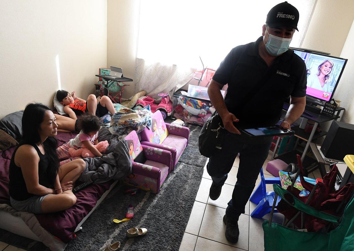 Code enforcement officer David Ceballos, with the City of Fresno, conducts an inspection in the apartment of Mai Vue at the Manchester Arms complex, March 31, 2021.