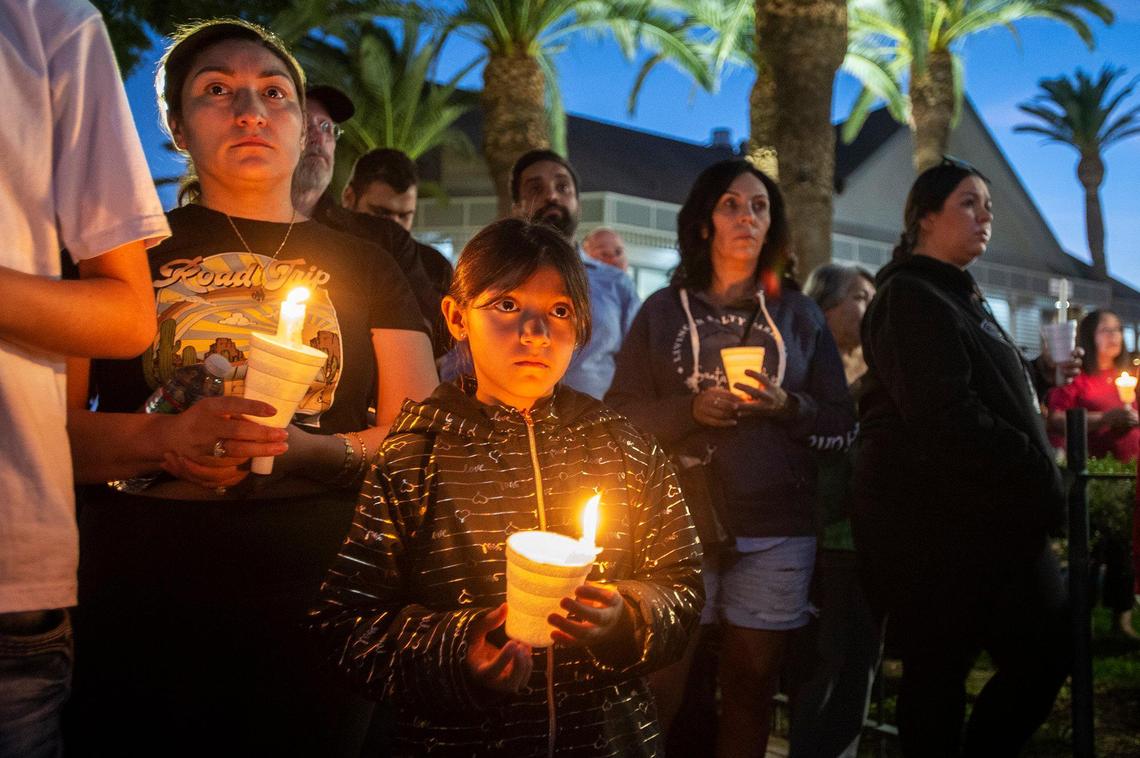 Monserrat Herrera, 8, of Merced, center, her mother Yubicela Sanchez, left, and her brother Christopher Herrera, 17, hold candles during a vigil for 8-month-old Aroohi Dheri, her parents Jasleen Kaur, 27, and Jasdeep Singh, 36, and her uncle Amandeep Singh, 39, at Bob Hart Square in Merced, Calif., on Thursday, Oct. 6, 2022. The bodies of the four kidnapping victims were found in a rural area of Merced County north of Dos Palos on Wednesday. Authorities said the family was kidnapped at gunpoint Monday from a Merced County business.