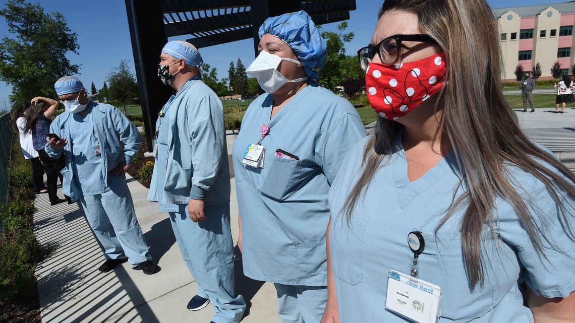 Medical technician Tina Toma, right, and other Valley Children’s Hospital staffers, wait for the flyover of F-15 fighter jets from 144th Fighter Wing of the California Air National Guard will come during their salute the state’s emergency workers and first responders,Wednesday May 13, 2020. The jets didn’t fly over the hospital but made a distant pass.