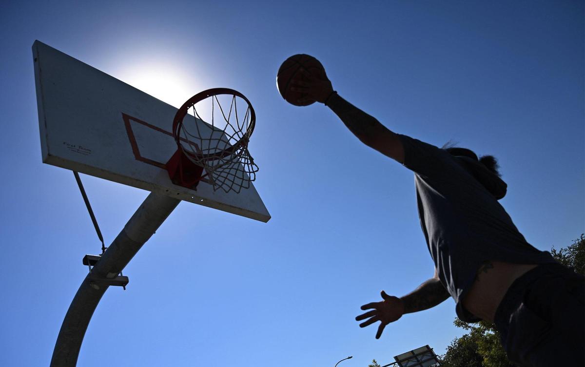 Visalia’s Devin Johnson plays basketball under a sweltering sun at Martin Ray Reilly Park’s courts as he waits for his girlfriend to get off work Wednesday afternoon, Sept. 7, 2022 in Fresno.