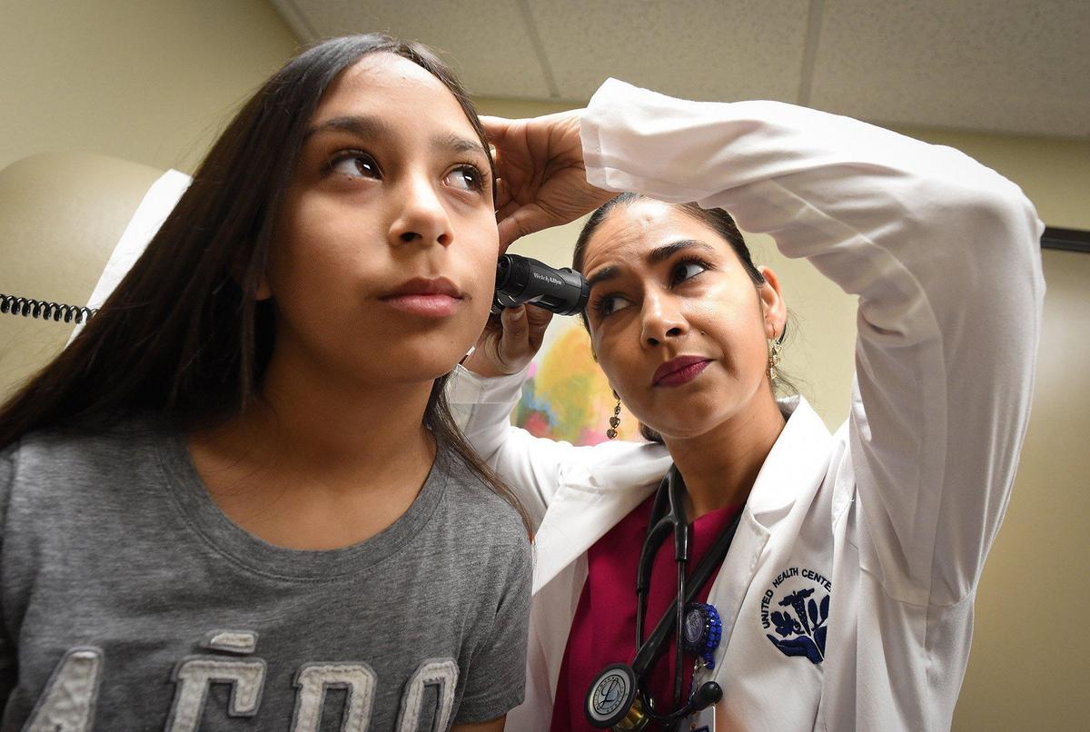 Pritpal Sidhu, nurse practitioner at United Health Center community clinic in Parlier, gives 12-year-old Hailey Resenez a checkup, January 30, 2020.
