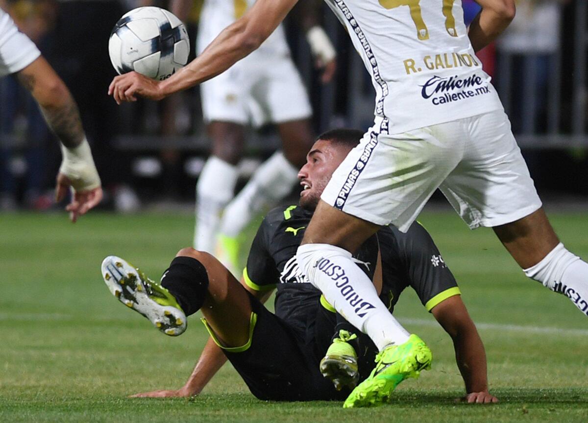 Chivas de Guadalajara’s Paolo Yrizar, bottom, tries to control the ball from the ground with Pumas UNAM’s Ricardo Galindo to the right Wednesday, March 23, 2022 in Fresno.