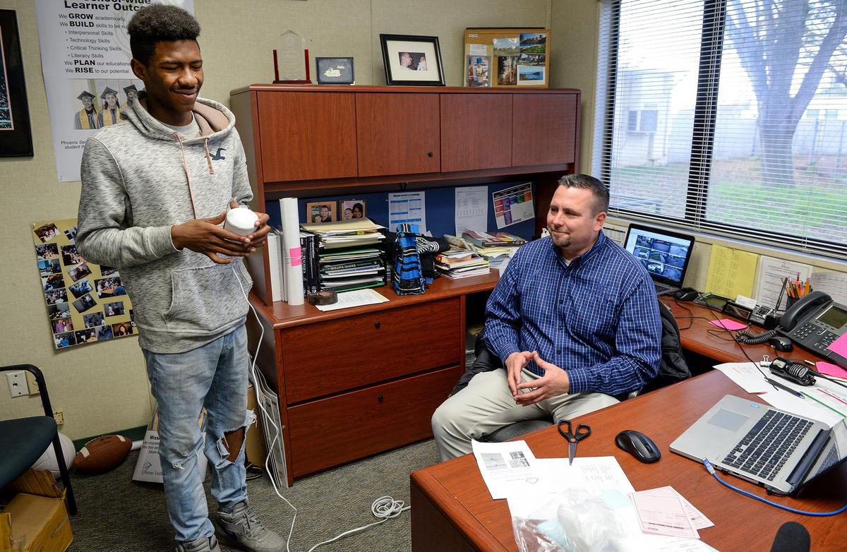 Kieshaun White, an 18-year-old who grew up in SW Fresno and has been detailing differences in air quality between north and south Fresno, works with Phoenix High School principal Mark McAleenan to configure an air quality monitor for the school on Tuesday, Dec. 11,2 018. White is working to install air quality monitors at high schools throughout Fresno Unified School District and developing an app so people can check air quality in real time on those school campuses.