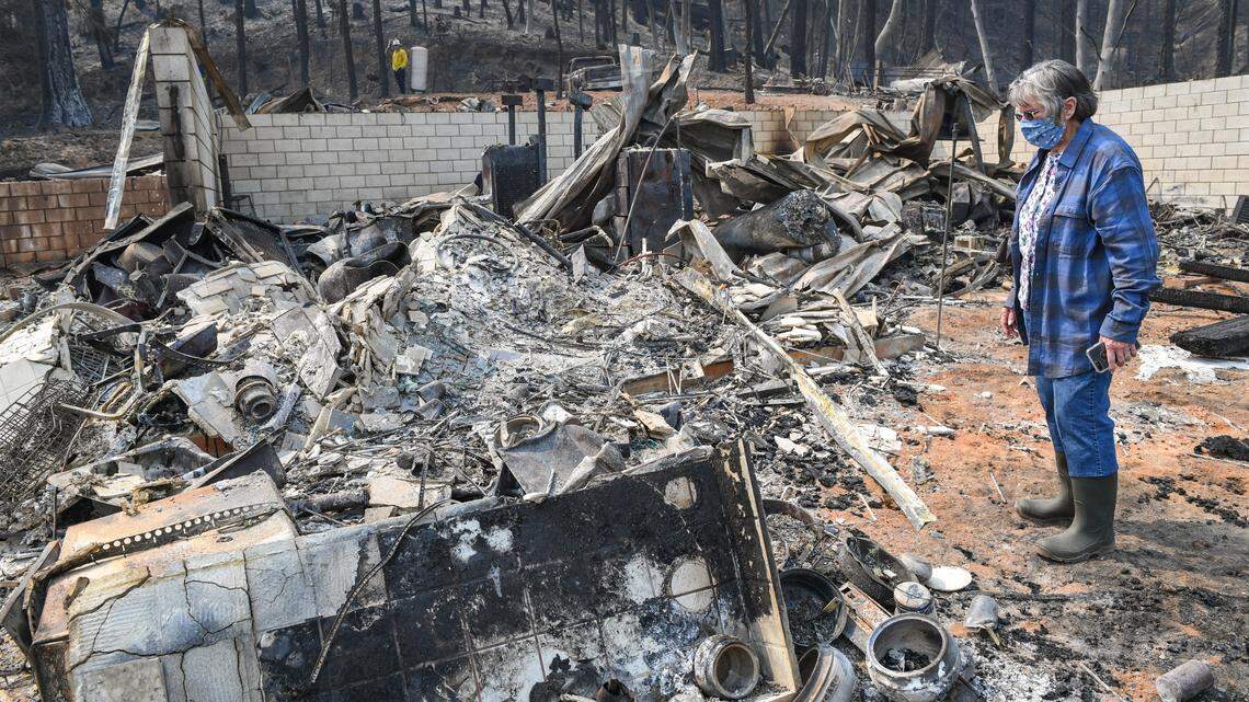 Gloria Sprague looks over the damage to her home on Auberry Road near Alder Springs on Tuesday, Sept. 22, 2020. Residents who lost their homes in the Creek Fire were being allowed to return to survey the damage and salvage any items.