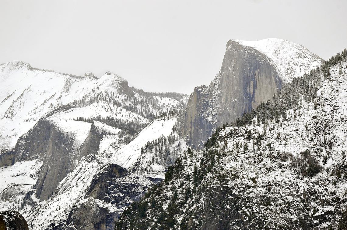 Half Dome and surrounding peaks loom over Yosemite Valley shrouded in snow, Tuesday, Dec. 4, 2018.
