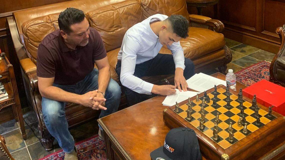 Evan Sanchez of Parlier signs with Golden Boy Promotions on Tuesday, Jan. 7, 2020 in front of Oscar De La Hoya.