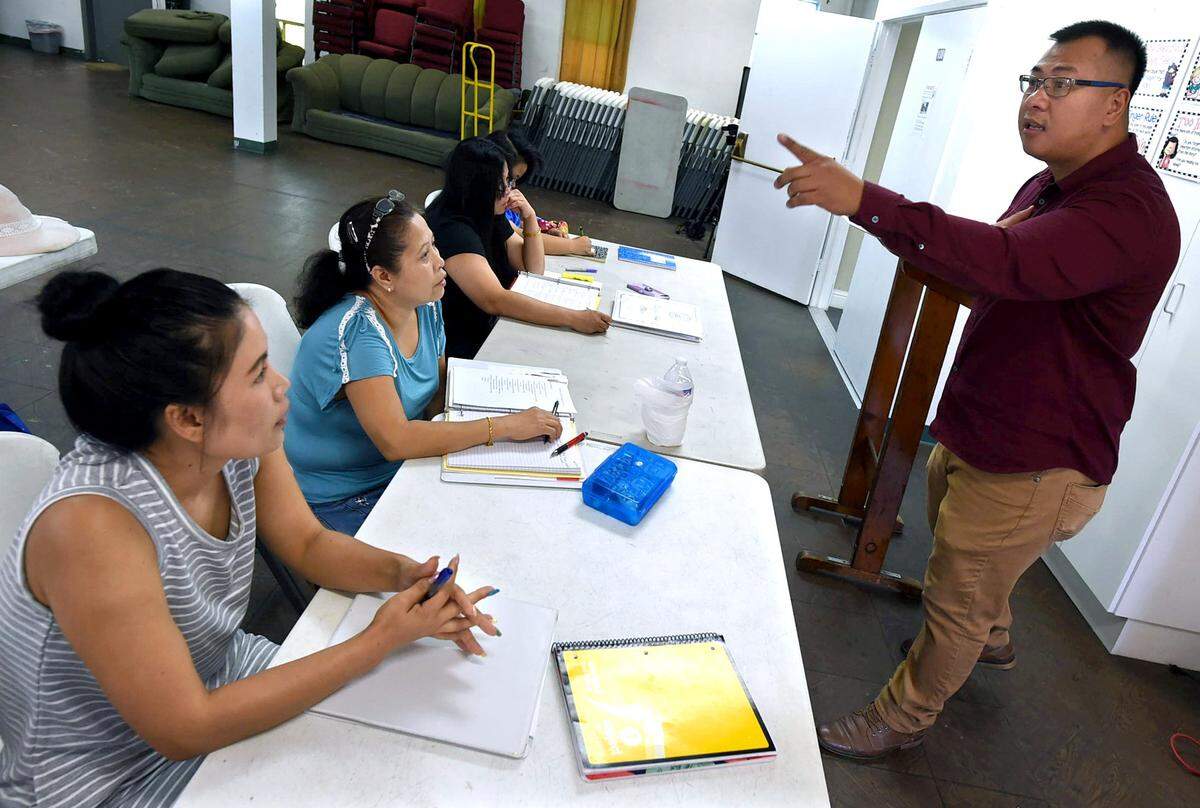 Students intently listen to Lucky Siphongsay as he conducts a citizenship and civics class at the Fresno Interdenominational Refugee Ministries, which works with ethnic communities from Laos, Cambodia and the Syrian refugees, Wednesday Aug. 22, 2018. Siphongsay is the program manager at FIRM.