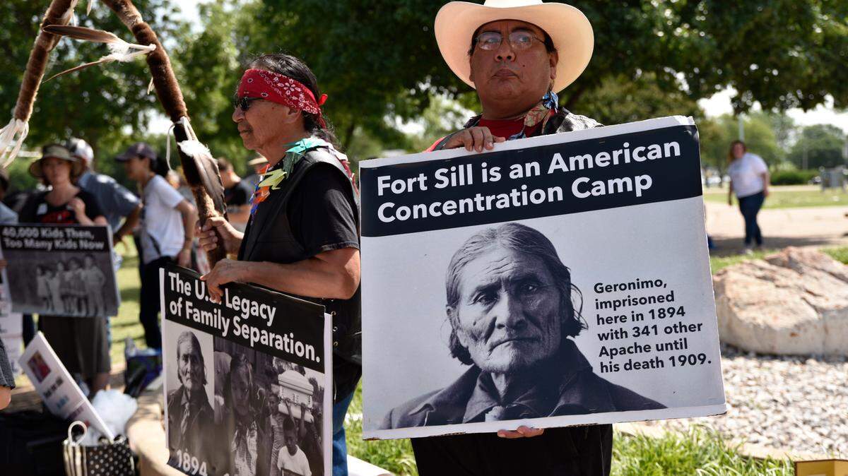 Toma Hubert, left, a Lakota Sioux tribe member, and Michael Topaum, with the Kiowa Tribe of Oklahoma, protest plans to house migrant children at Fort Sill, in Lawton, Okla., June 22, 2019. Protesters called the plan for the site, home to an internment camp for Japanese-Americans during World War II, a return to one of the nation’s great shames.