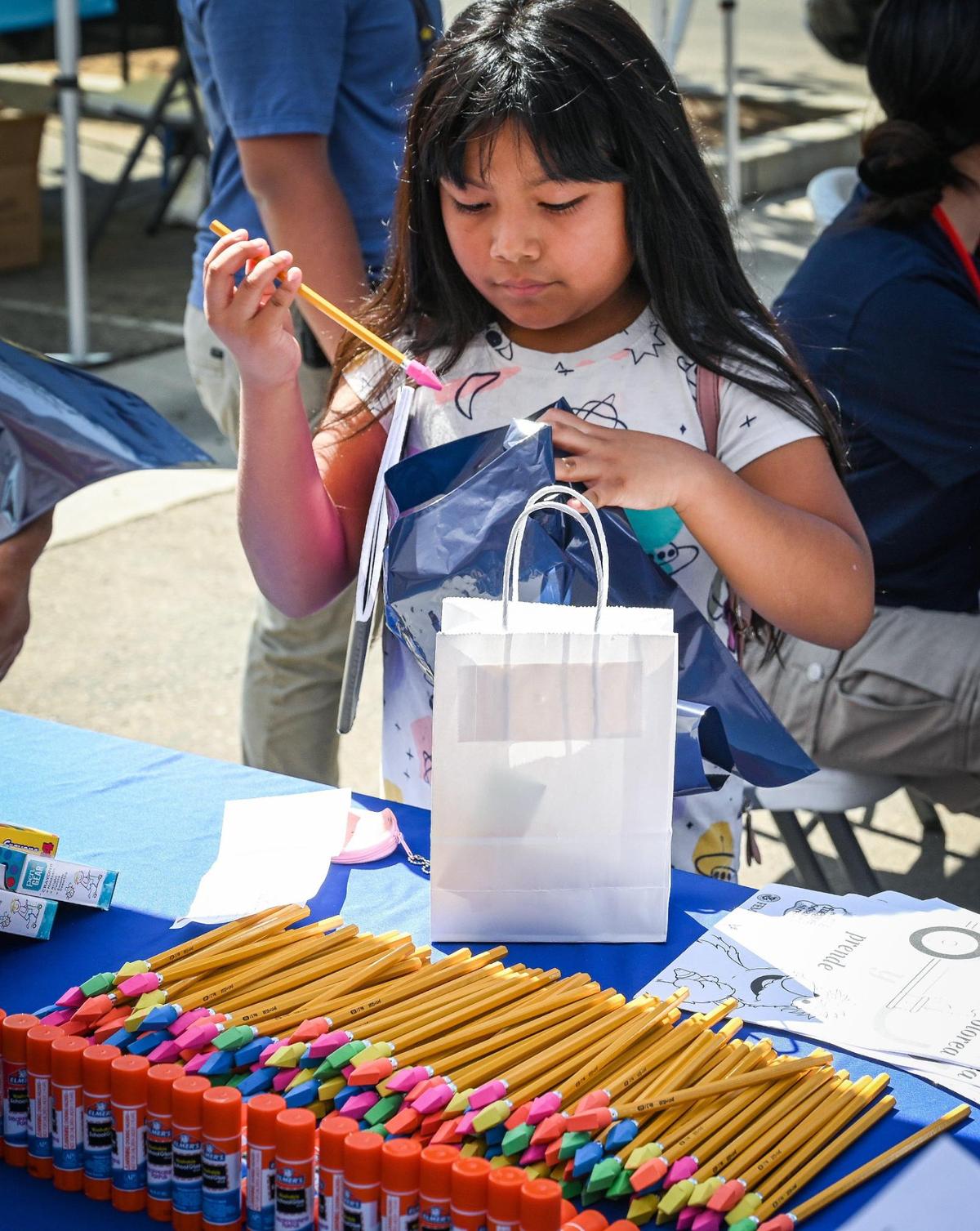 Audris Hipolito, 8, of Fresno picks out a pencil during a backpack and school supplies giveaway for the new school year at United Way Fresno and Madera Counties in Fresno on Saturday, Aug. 6, 2022.