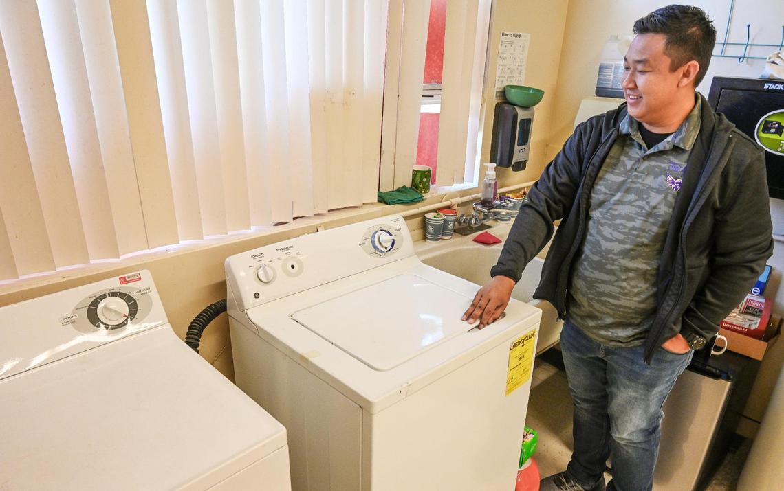 Fort Miller Middle School teacher Eric Calderon stands next to the school’s current washer and dryer, which are showing some wear, on Monday, March 27, 2023. Calderon, with help from trustee Andy Levine, was able to secure funding for a new washer and dryer for not only Fort Miller, but all middle schools throughout the district to give low-income students access to laundry equipment to keep their clothes clean.