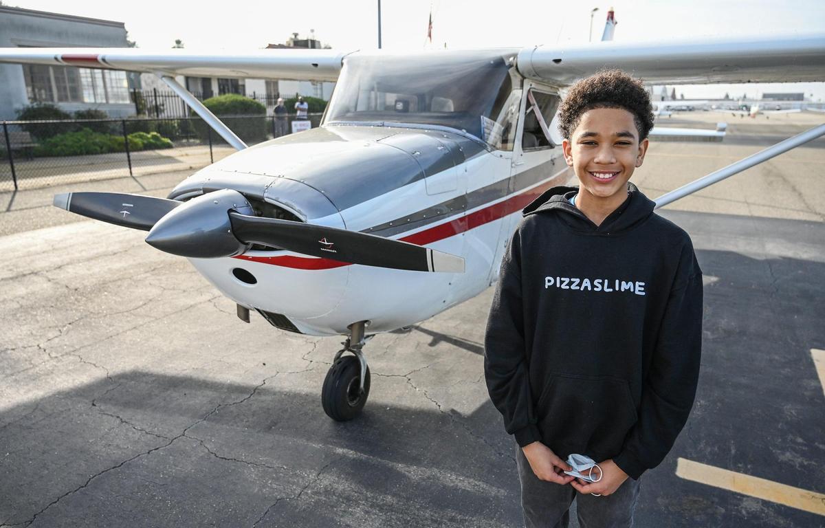 Sammy Taylor, 12, of Fresno stands next to the plane he’s been learning to fly in.