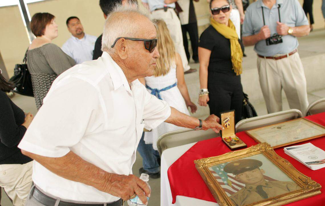 Norberto Rojas shows photo and medals of his son, Jesus Bermudez Rojas, during 2008 rededication of Rojas-Pierce Park in Mendota.