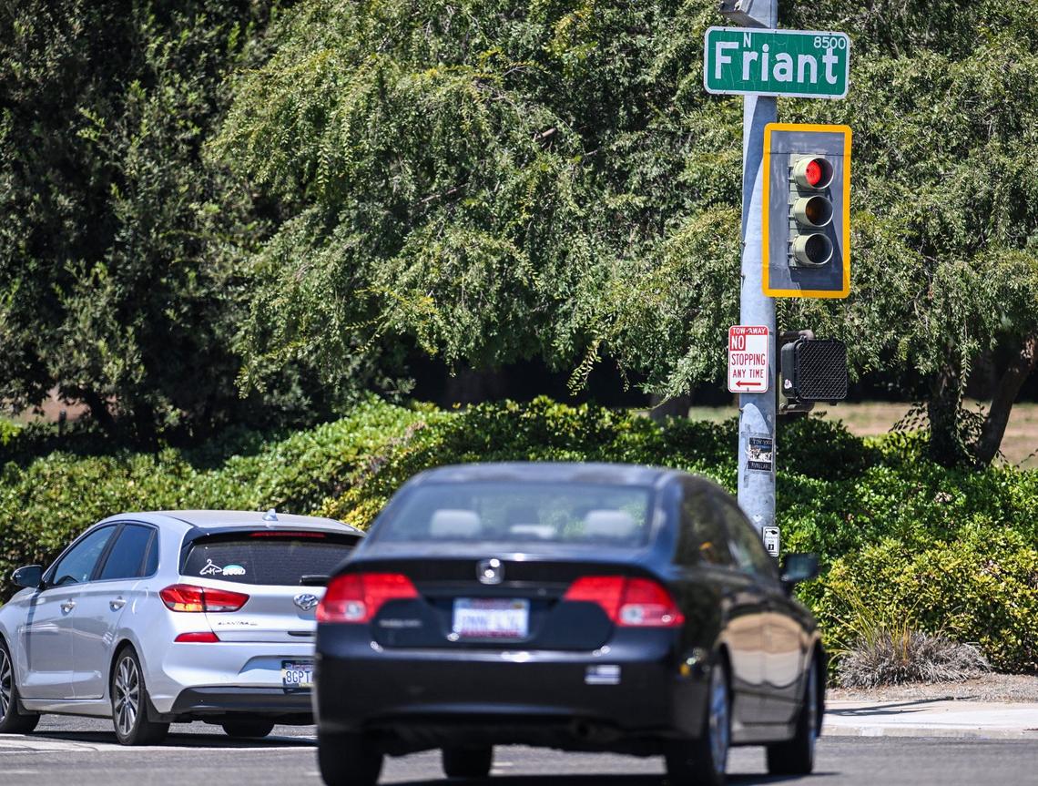 Traffic crosses the intersection at Audubon and Friant Road near Woodward Park on Monday, Aug. 5, 2024. Several safety measures have been implemented along a dangerous section of Friant Road in north Fresno including high-visibility crosswalks, reflective signal backplates, and no right turn on red signs.