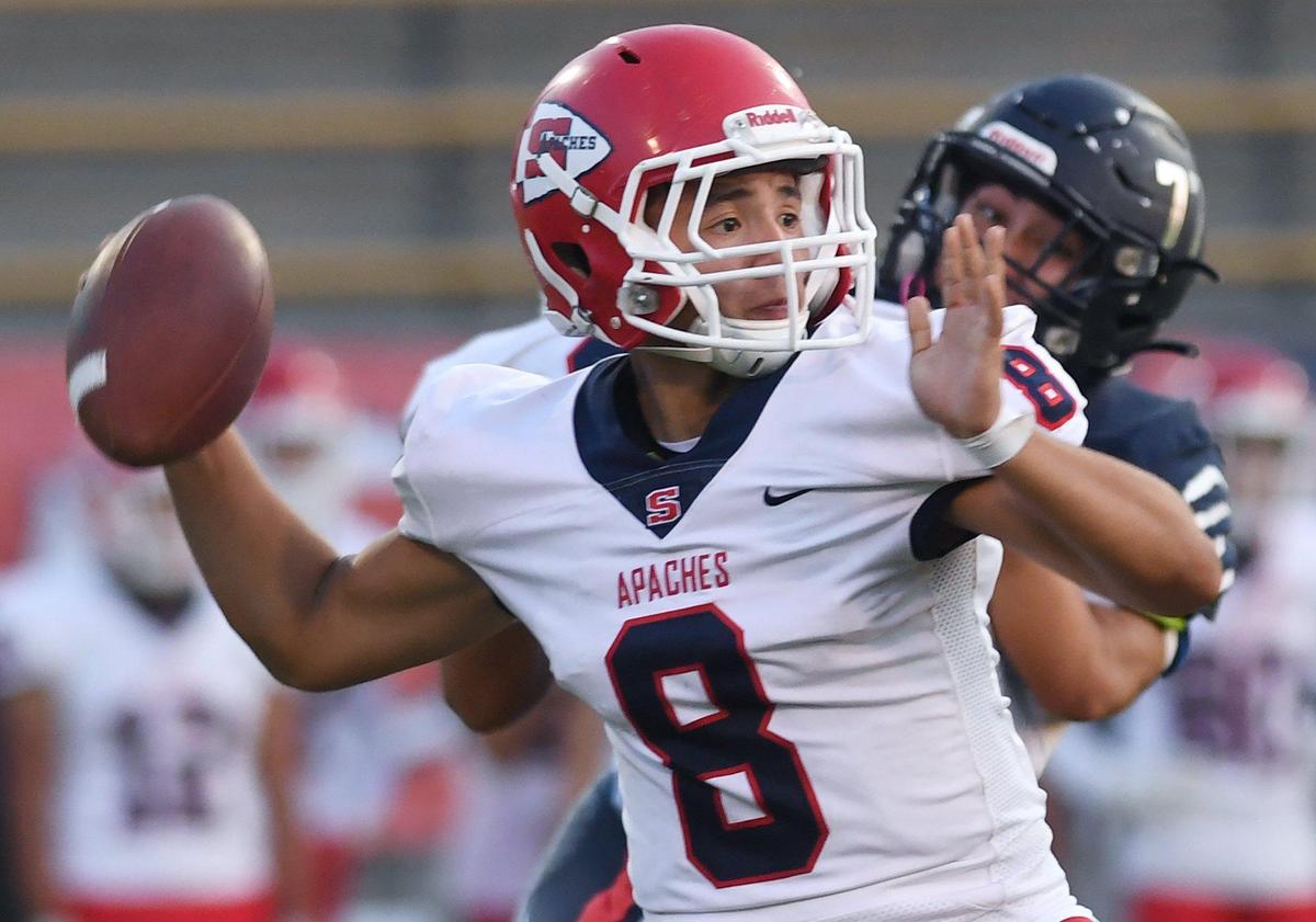 Sanger quarterback Josaiah Duarte, left, passes as Clovis East’s Adam Montgomery rushes in the background Thursday, Sept. 23, 2021 in Clovis.