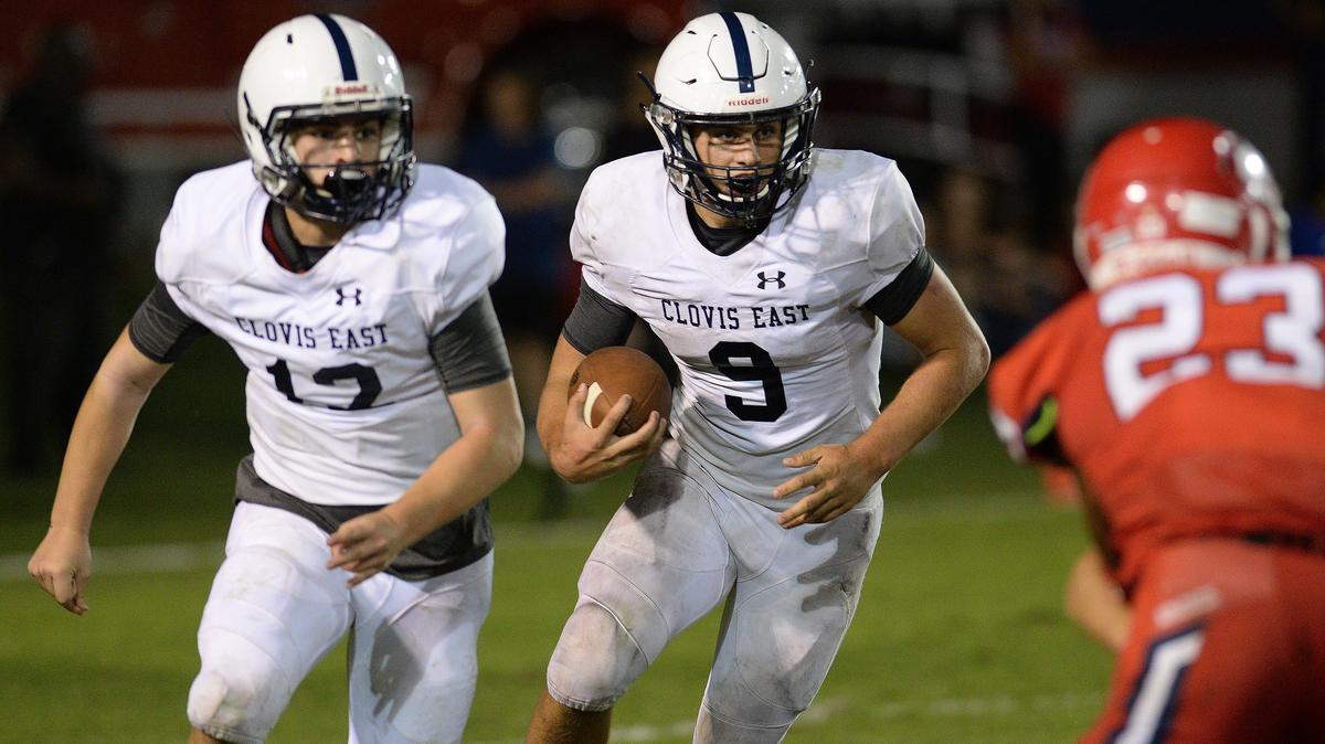 Clovis East’s Ryan Hunt, center, takes the ball on a run against Sanger with blocking help from Josh Sue, left, in their game at Tom Flores Stadium in Sanger on Friday, August 31, 2018.