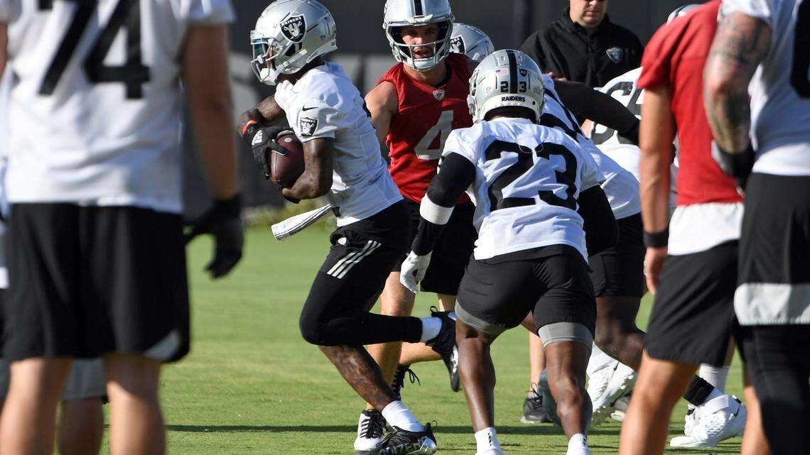 Las Vegas Raiders quarterback Derek Carr (4) hands off the ball during an NFL football practice Saturday, July 31, 2021, in Henderson, Nev.