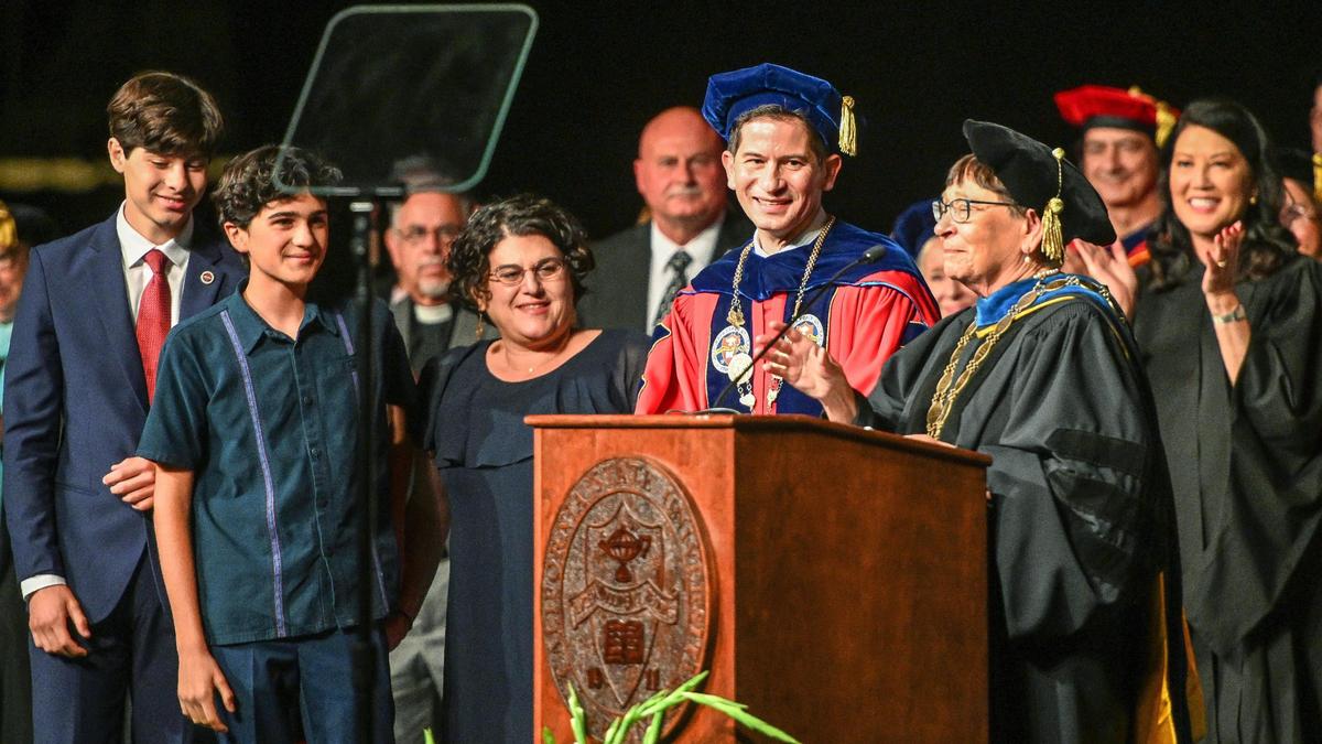 Dr. Jolene Koester, right, interim chancellor for the California State University, conducts the investiture ceremony for Dr. Saúl Jiménez-Sandoval, standing with his family, to formally become Fresno State’s ninth president at the Save Mart Center on Friday, Sept. 9, 2022.