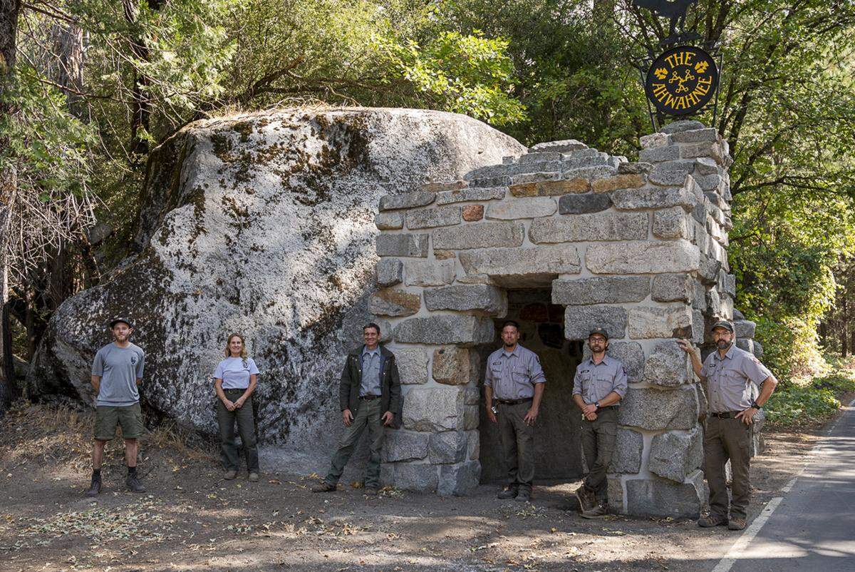 Members of Yosemite National Park’s historic preservation team at The Ahwahnee’s refurbished historic gatehouse on Oct. 7, 2021 after the hotel’s new welcome was installed. A historically accurate replica was made after the original sign was stolen from the Yosemite Valley hotel in 2016.
