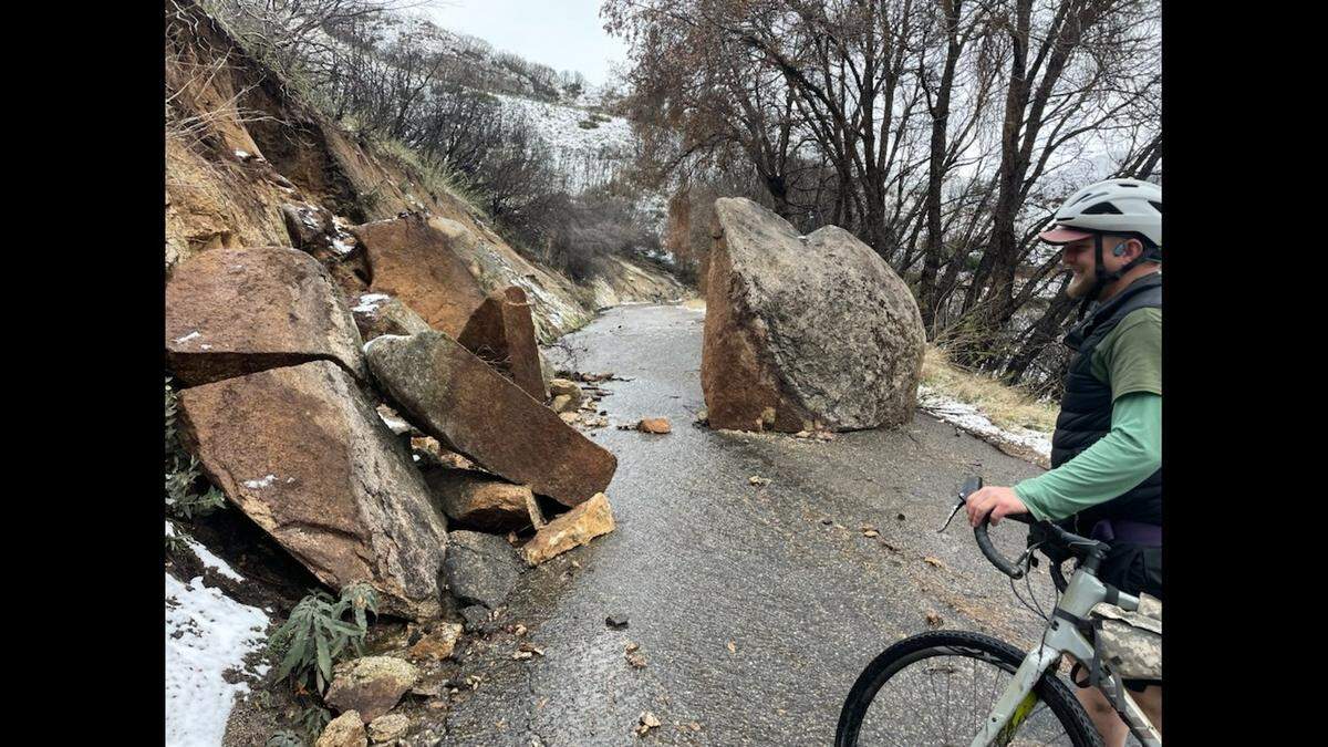 Cyclist Corky Conover looks at boulders on Mineral King Road on Jan. 13, 2023.