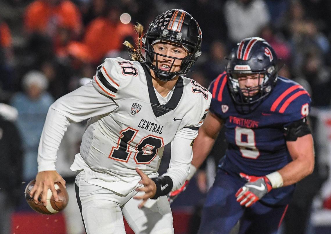 Central quarterback Dayton Tafoya, left, takes off on a keeper as Memorial’s James Mahoney chases after in the first half of their quarterfinal playoff game at San Joaquin Memorial on Thursday, Nov. 10, 2022.