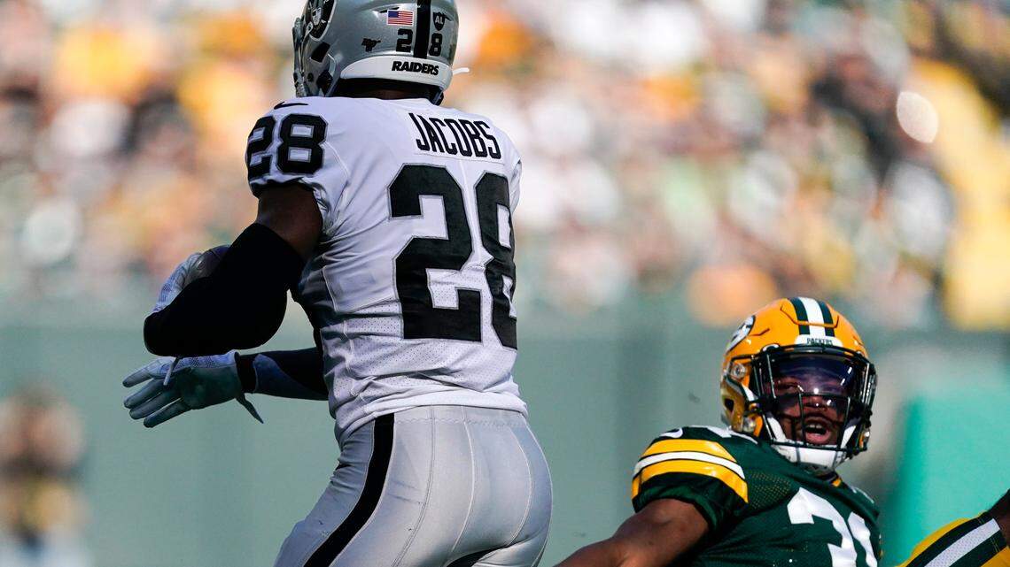 Oakland Raiders’ Josh Jacobs gets past Green Bay Packers’ Adrian Amos during the first half of an NFL football game Sunday, Oct. 20, 2019, in Green Bay, Wis.