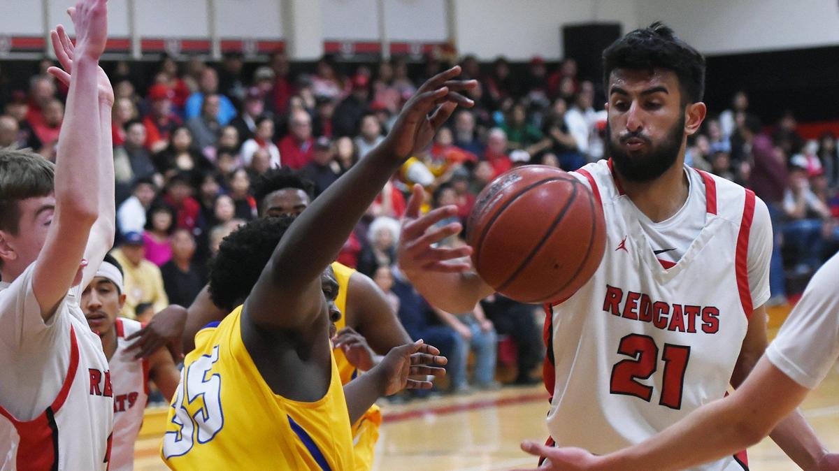 In a FILE photo, Corcoran’s Demarcus Thompson, left, loses the ball to Fowler’s Amneet Basra, right, in the Central Section Division V boys basketball semifinal playoff Tuesday night, Feb. 25, 2020 in Fowler.