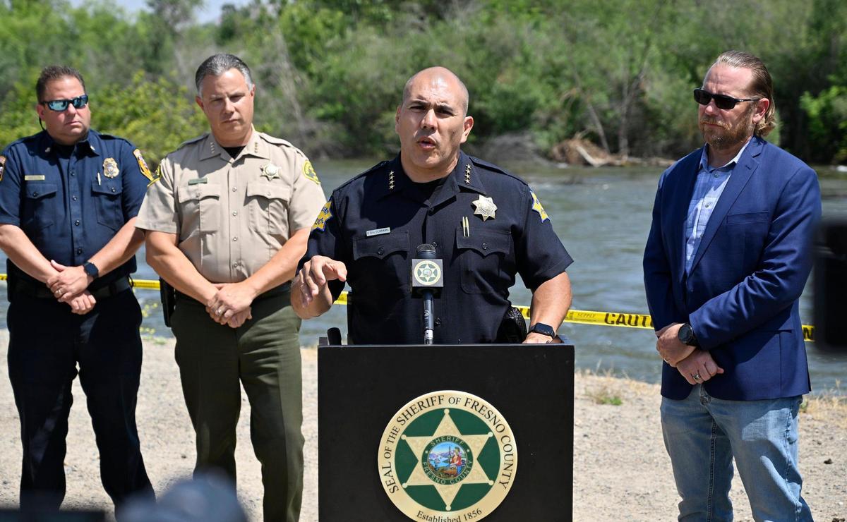 El jefe de la Policía de Fresno, Paco Balderrama, con el alguacil John Zanoni, a la izquierda, y el supervisor de la Junta Nathan Magsig, a la derecha, se dirige a los medios de comunicación durante una conferencia de prensa a orillas del río Kings; la Oficina del Alguacil del Condado de Fresno refuerza el cierre de las zonas recreativas a lo largo de los ríos locales debido a las inundaciones. Imagen del jueves 25 de mayo de 2023, cerca de Centerville.