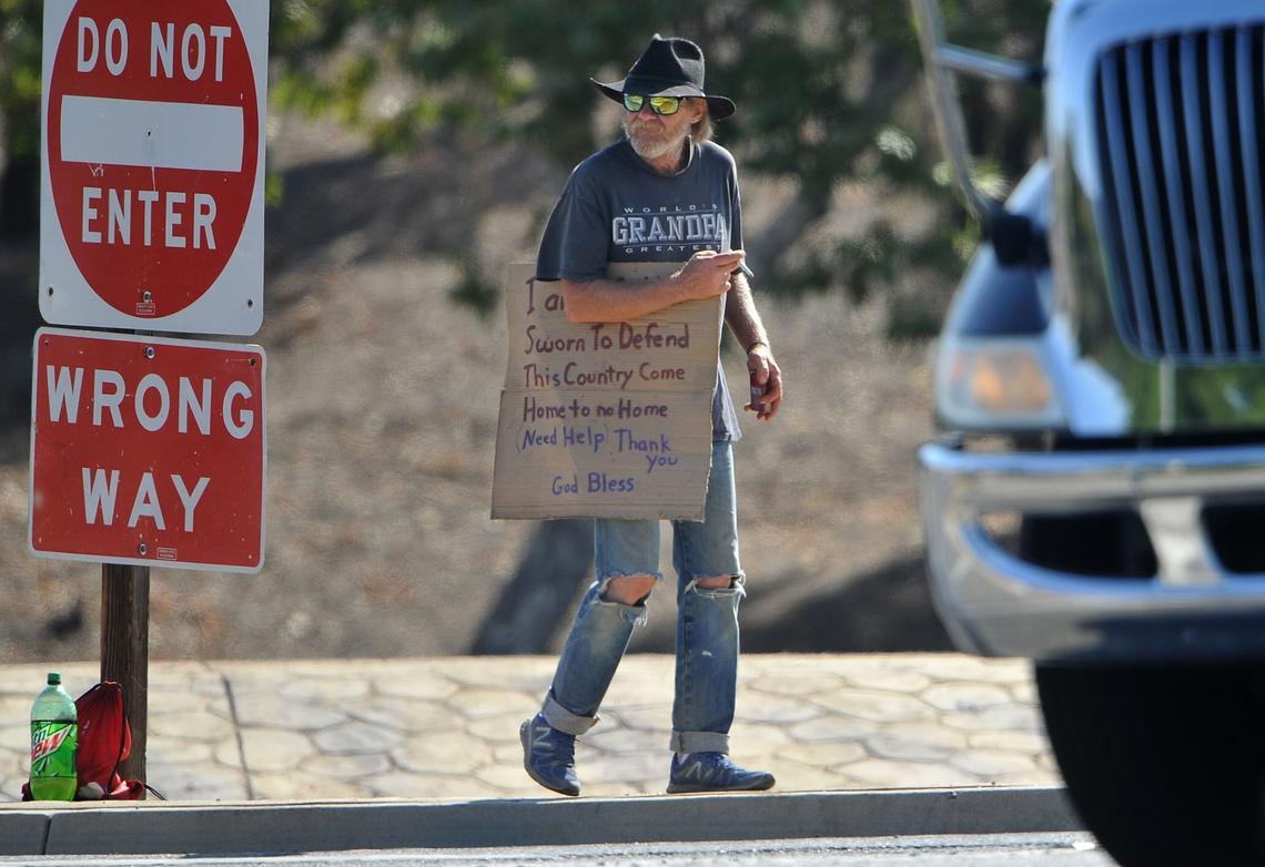 The top line of this panhandler’s sign reads “I am a soldier.” He works a freeway 41 off-ramp at Herndon Avenue in north Fresno on Wednesday morning, July 4, 2018.