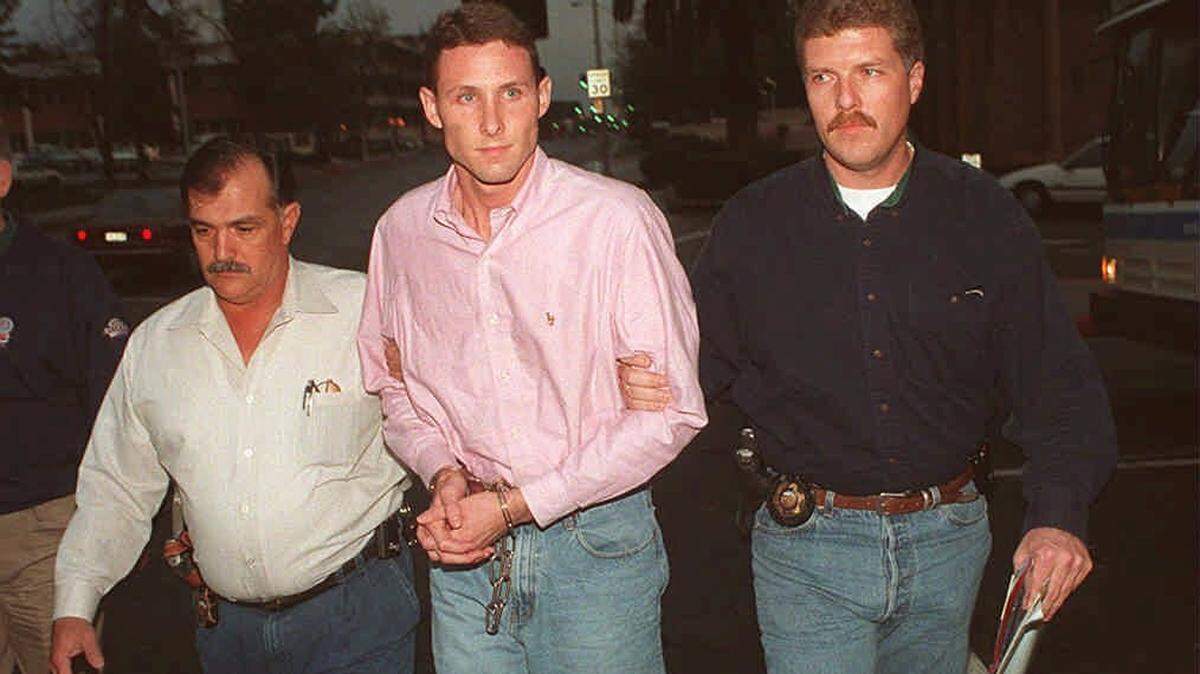 Fresno sheriff’s detectives John Souza, left, and Chris Curtice escort Dana Ewell after he was arrested in the slayings of family members in 1995.