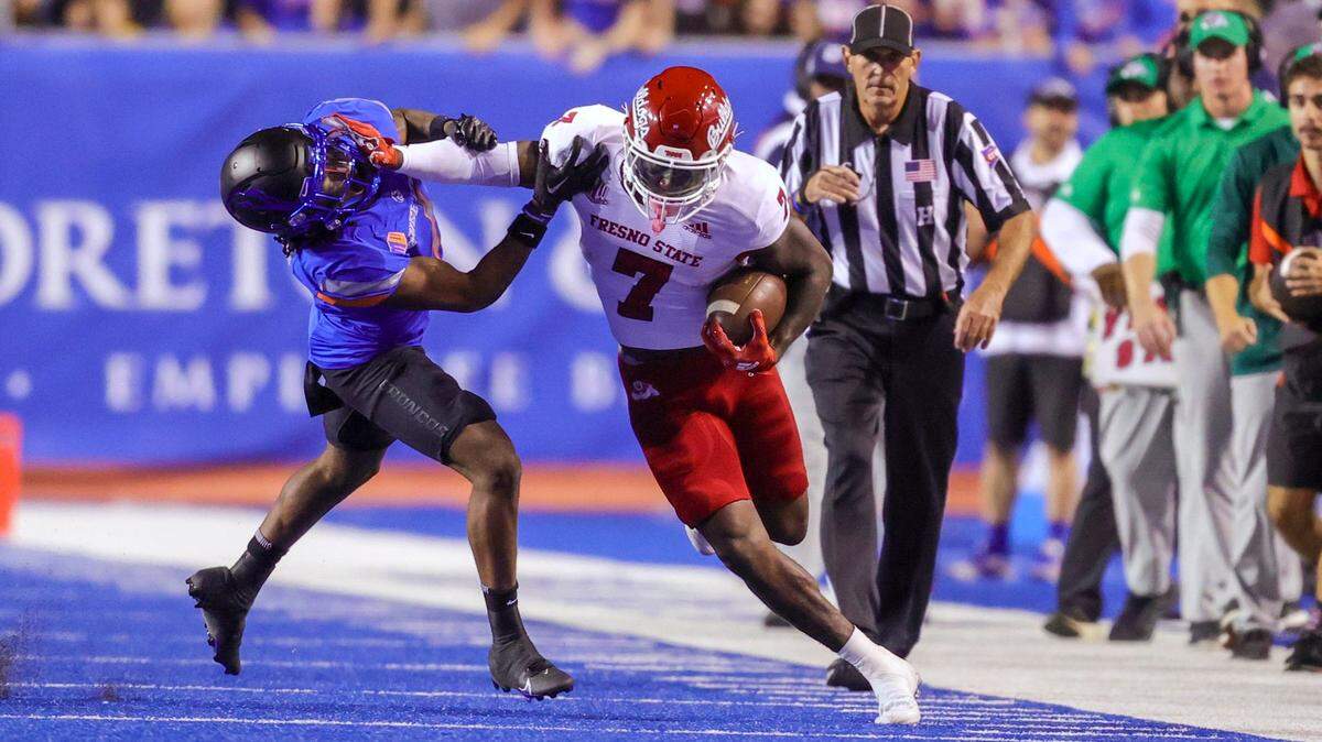 Fresno State running back Jordan Mims (7) stiff-arms Boise State safety Rodney Robinson (4) on a run along the sideline during the first half of an NCAA college football game Saturday, Oct. 8, 2022, in Boise, Idaho. (AP Photo/Steve Conner)