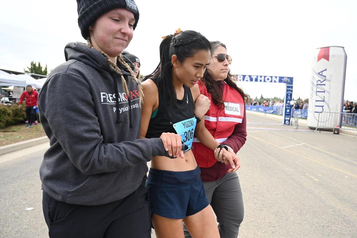 Yuzki Oey, center, from Goleta, California, is helped by medical staff after she crossed the finish line at the annual Two Cities Marathon on Sunday, Nov. 6, 2022, in Fresno. Oey was the top female finisher in the 26.2-mile event with a time of 2 hours, 58 minutes.