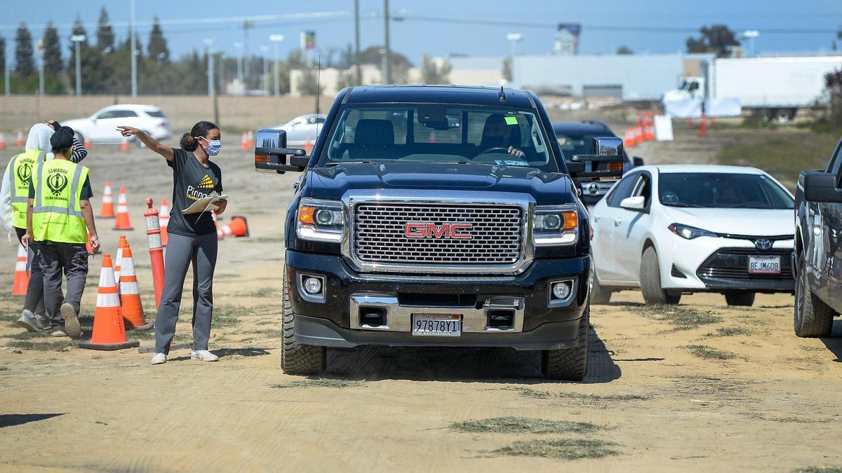 Volunteers help direct traffic during a COVID-19 vaccination and resource fair for over 1000 Punjabi food and agriculture workers at the Sikh Center of the Pacific Coast Gurdwara in Selma, on Saturday, March 27, 2021.